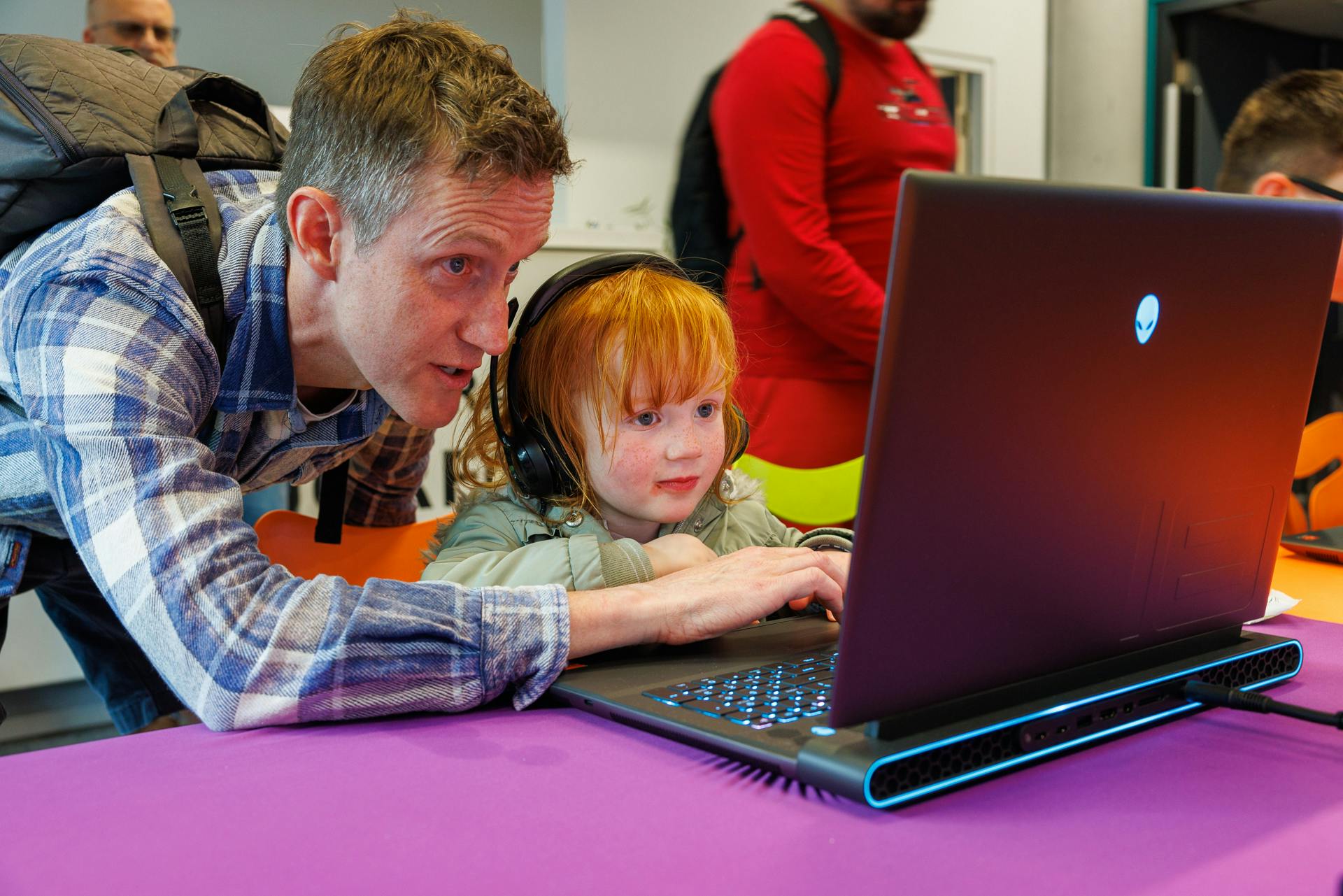 Image of little girl and father typing on laptop