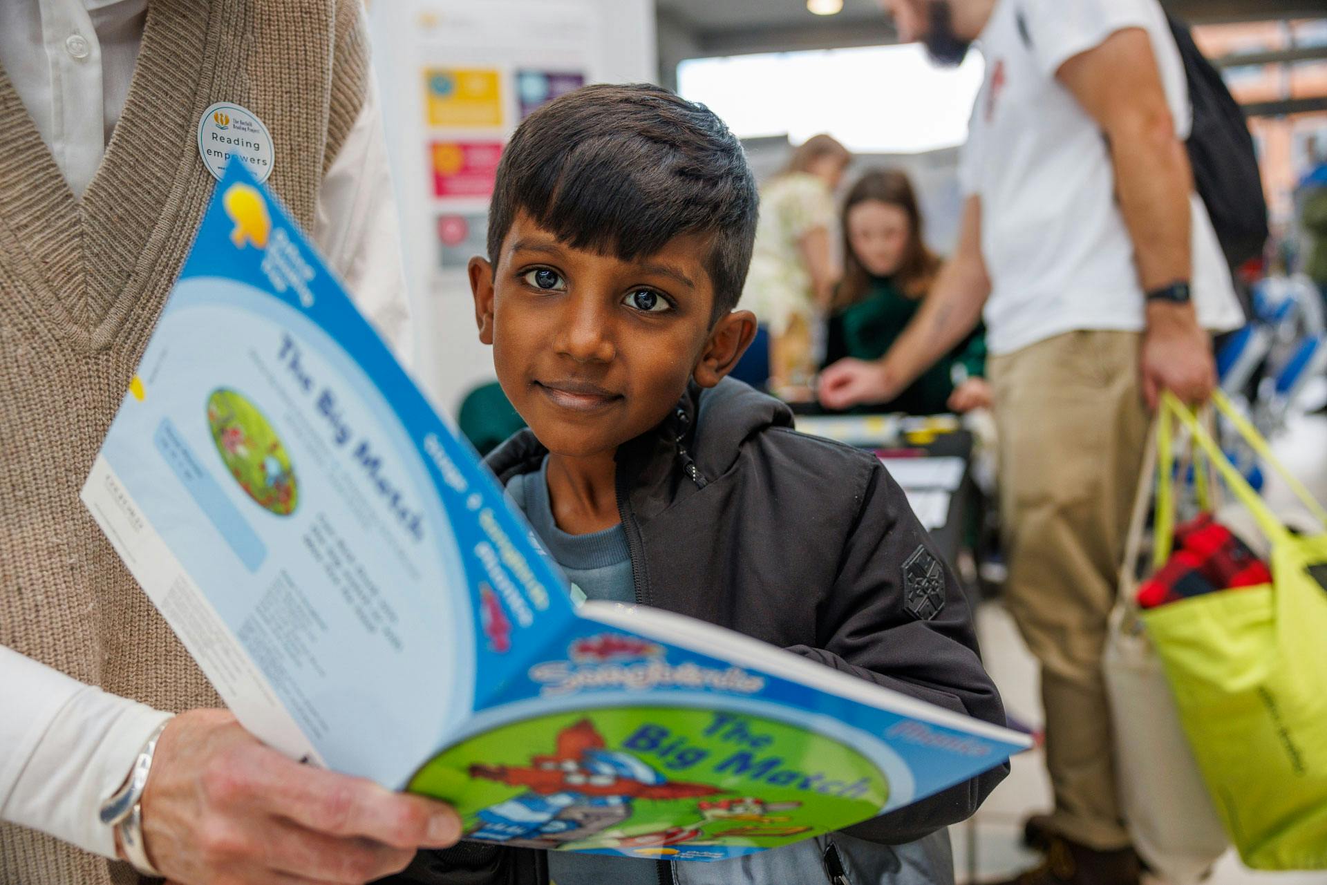 Young boy reads a colourful book