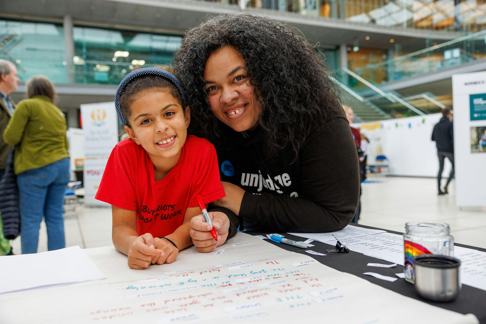 A mother and daughter smiling while in the Norwich Book Festival Imaginarium.