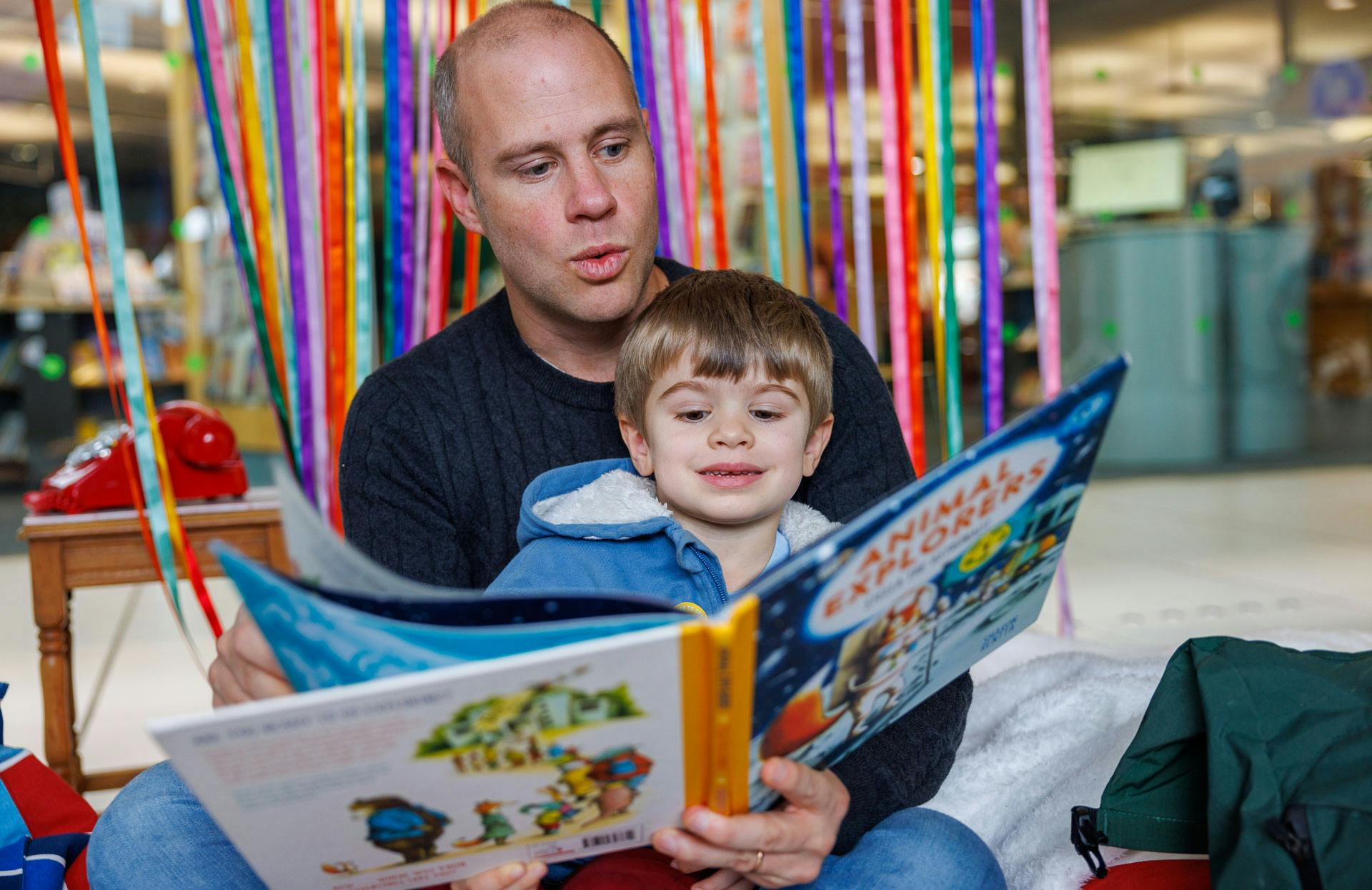 A dad reads Animal Explorers to his son at Norwich Book Festival