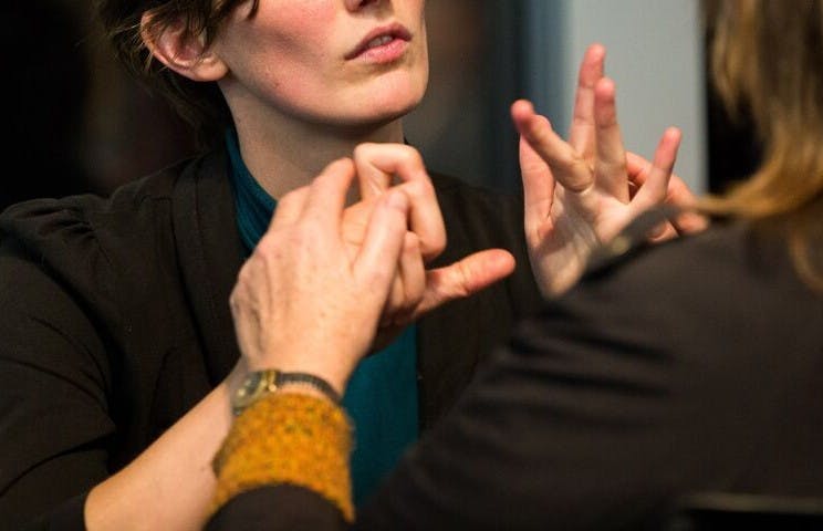 Two people communicating using tactile signing.