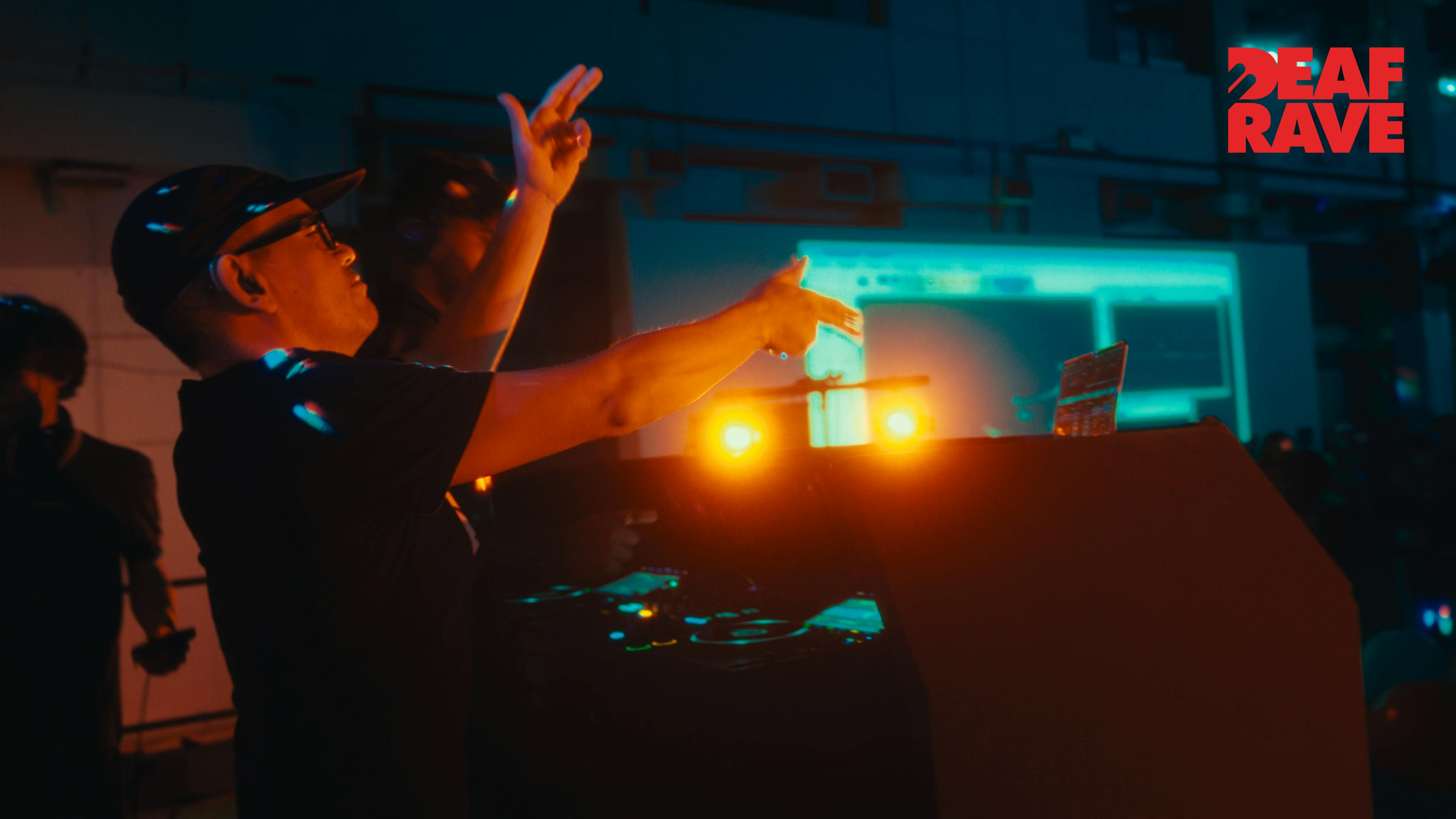 A DJ shooting finger guns.