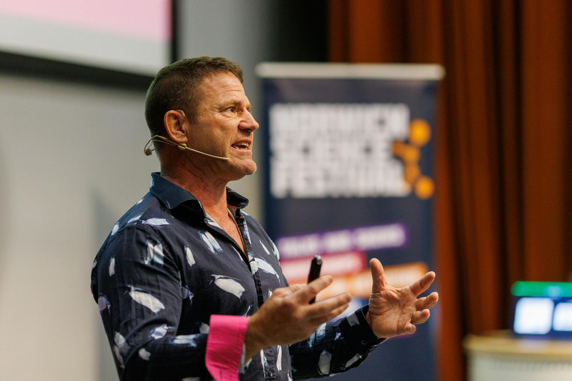Steve Backshall on stage talking while wearing a headset microphone.