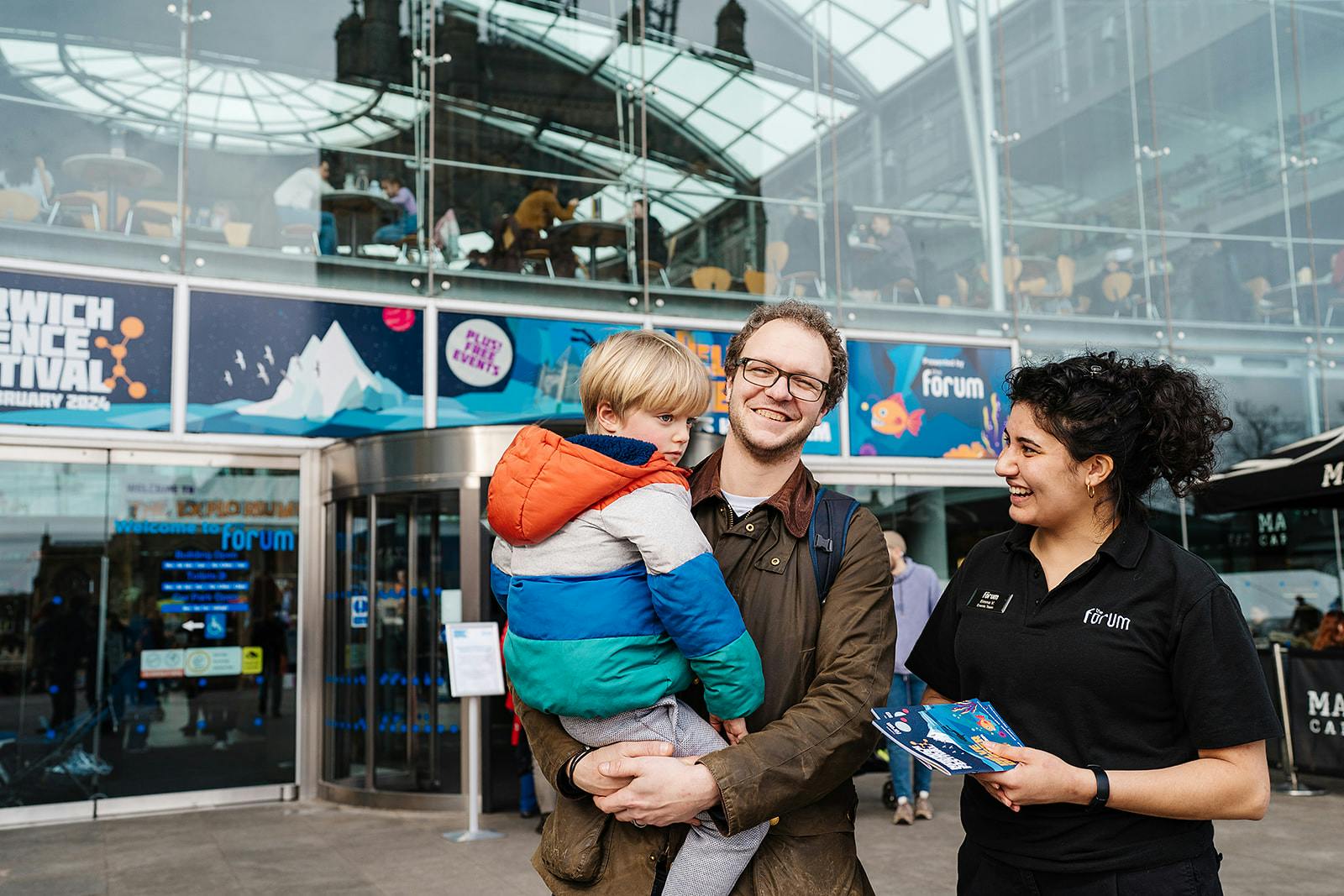A member of staff speaks to visitors outside The Forum during Norwich Science Festival