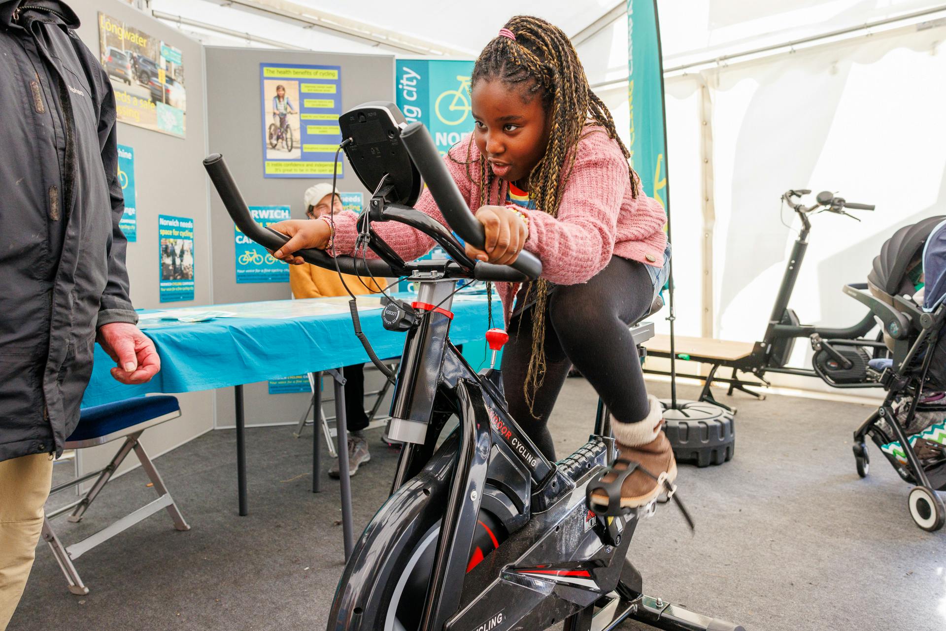A child rides a bike in the Explorium marquee at Norwich Science Festival 2024