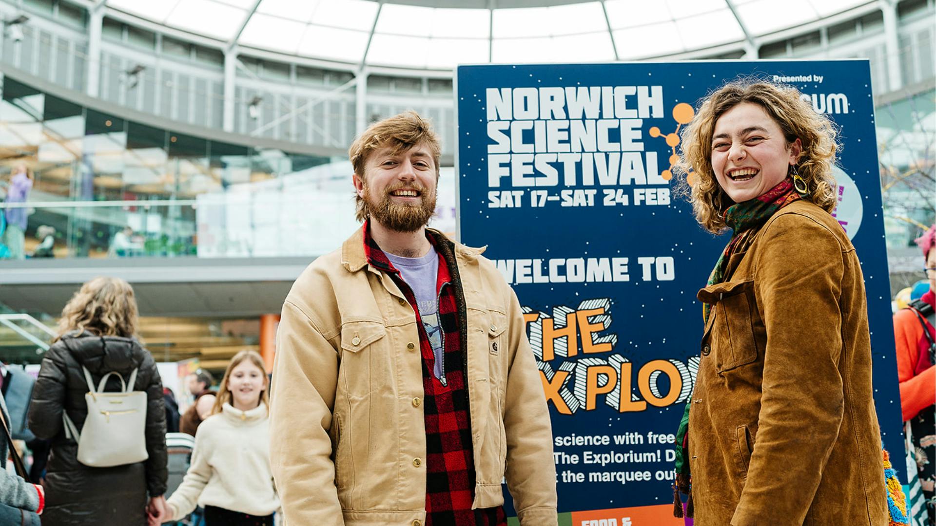 Two visitors to the Explorium at The Forum laugh and smile at the camera