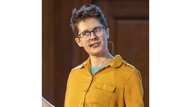 Nate Rae performing on stage in a yellow shirt.