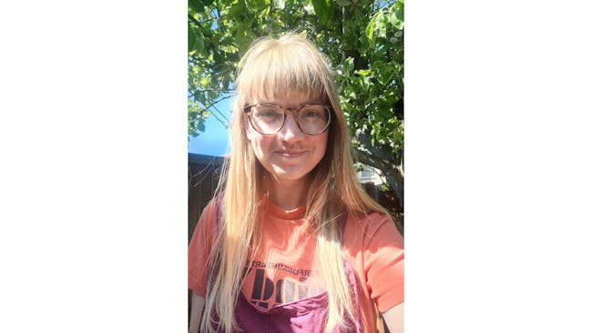 Illustrator Rose Feather sitting in a garden.