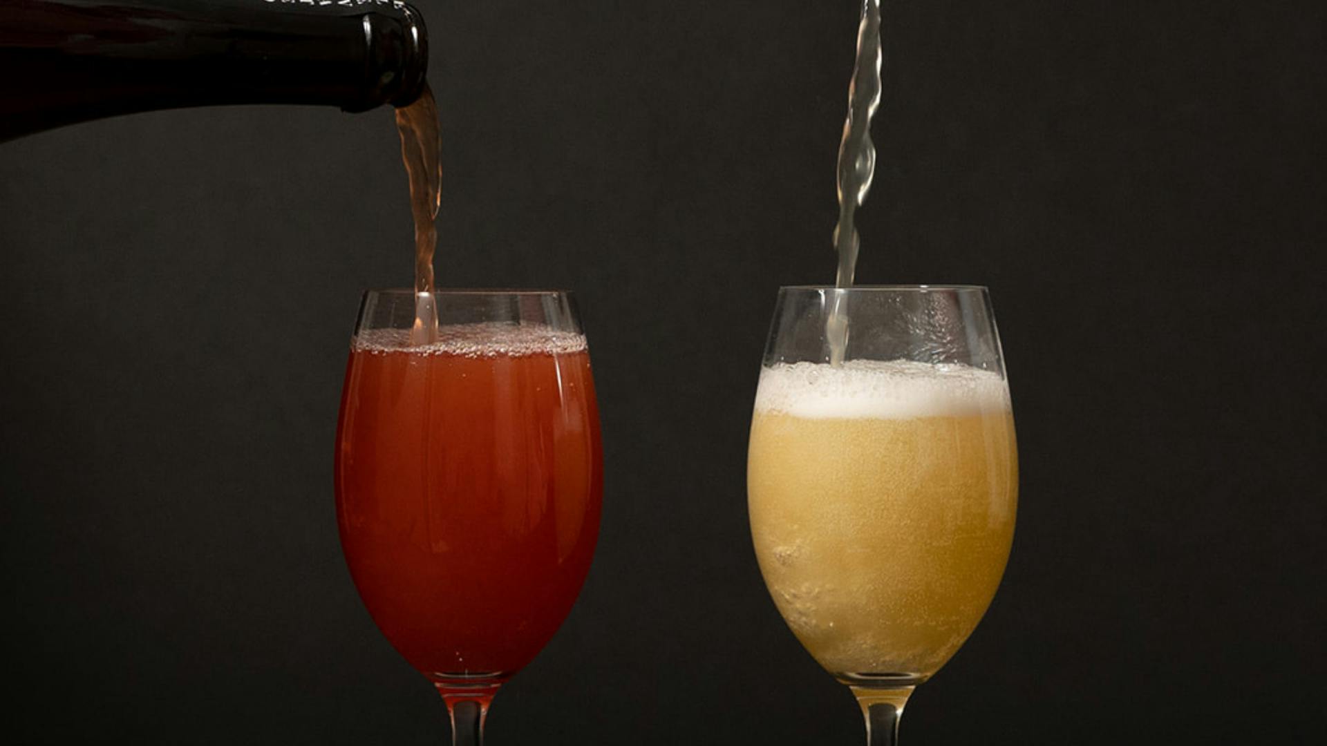 Kombucha being poured into two glasses.