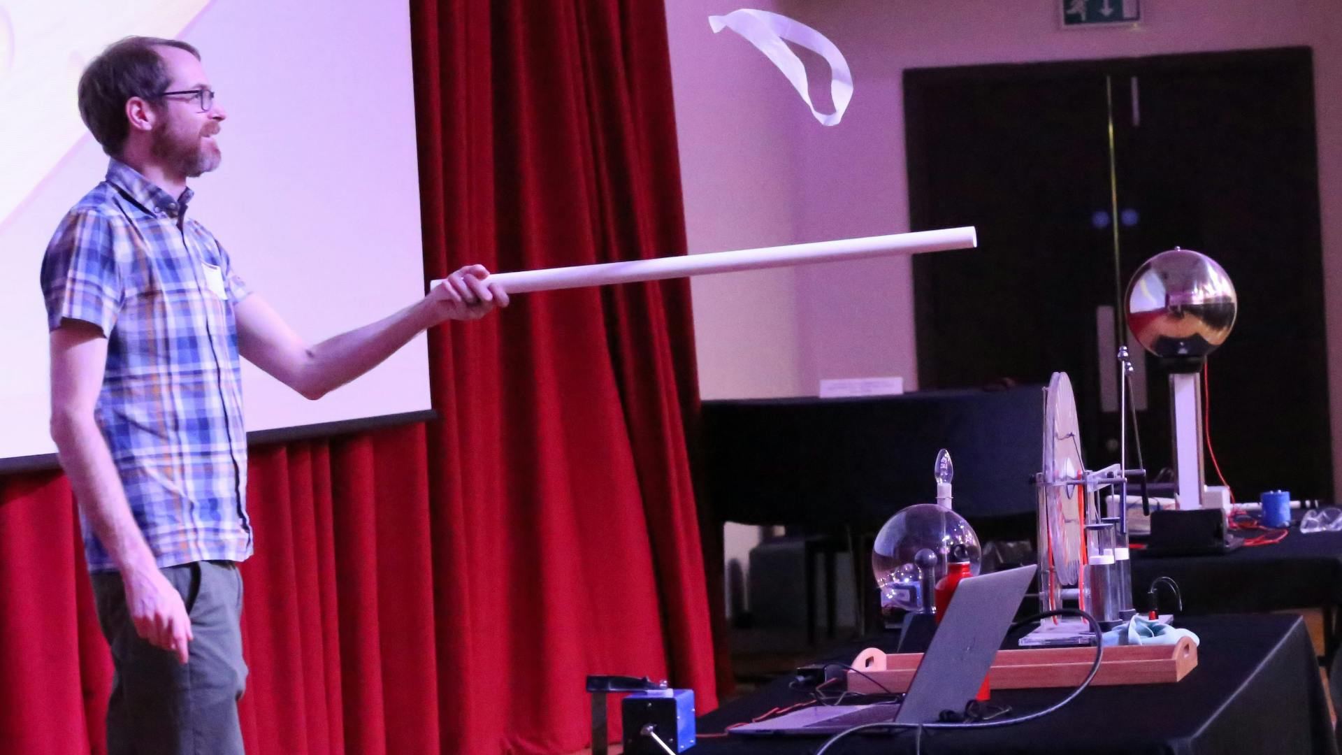 web-zap.png Scott Marley holding a long tube on stage.