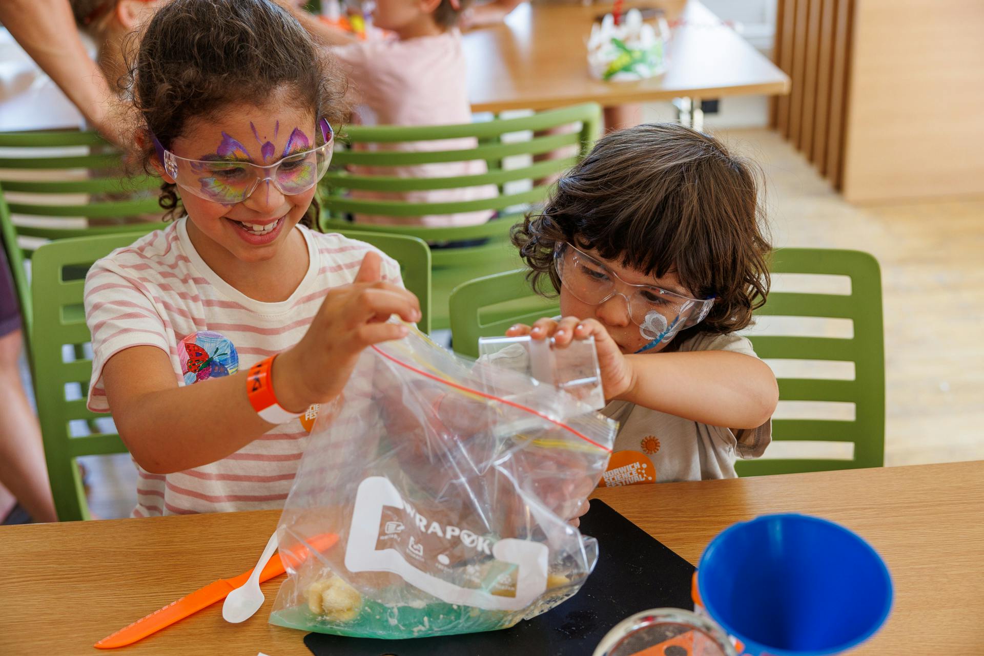 Two children wearing goggles as they extract DNA from bananas
