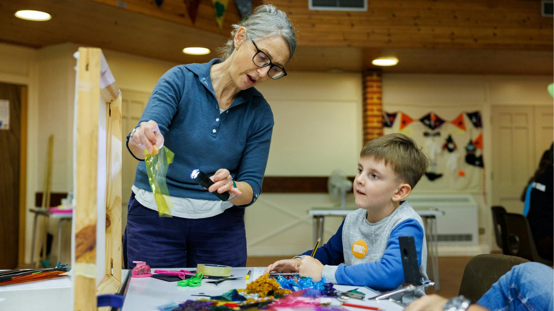 A member of staff from Luminous Tales shows a child how light travels through different materials
