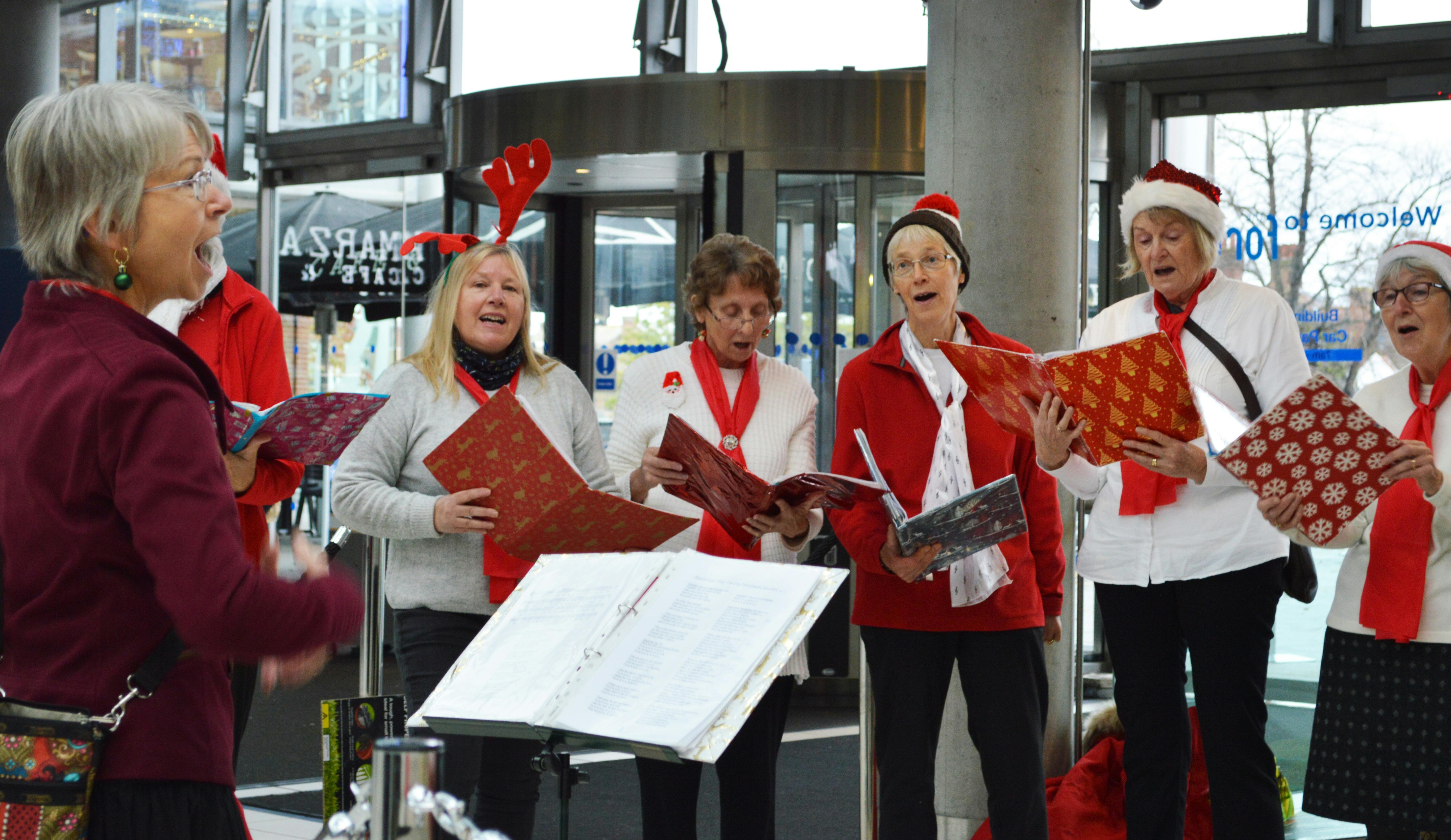 Members of Village Voices singing Christmas Carols