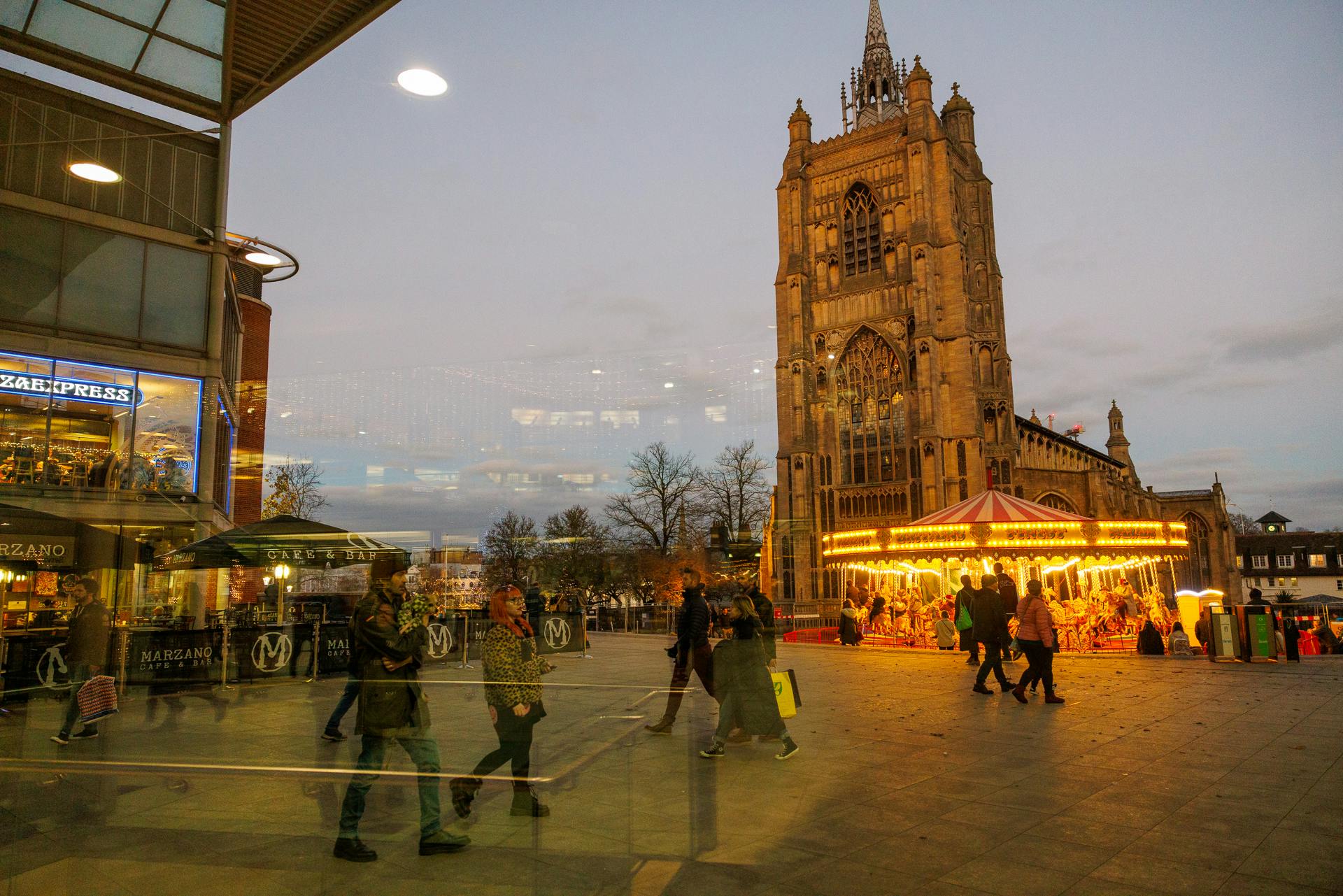 A view through The Forum's glass across a carousel, over to St Peter Mancroft